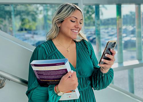 A professionally-dressed blonde woman holding a phone